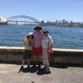 Mitchell, Brendan, and Deirdré in front of a view of the Sydney Harbour Bridge