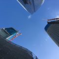 looking up between three tall buildings, two of them under construction