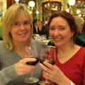 Deirdré and Robyn toasting at a restaurant in Paris